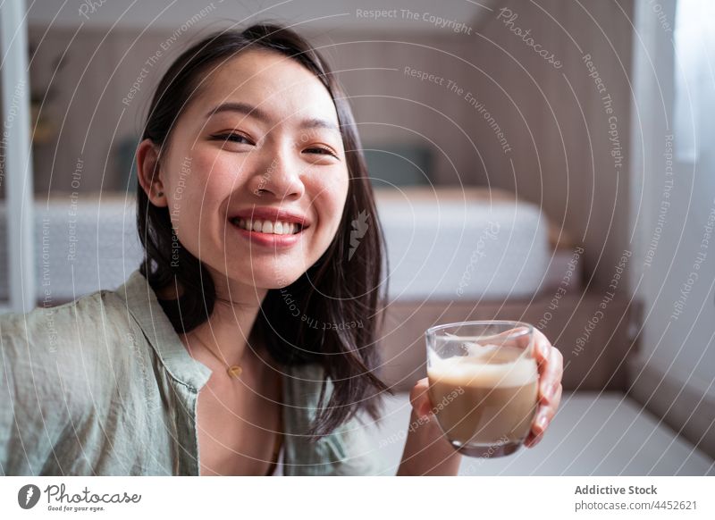 Happy Asian woman with coffee at home freelance desk portrait using gadget text blogger author asian online portable hot drink female beverage self employed