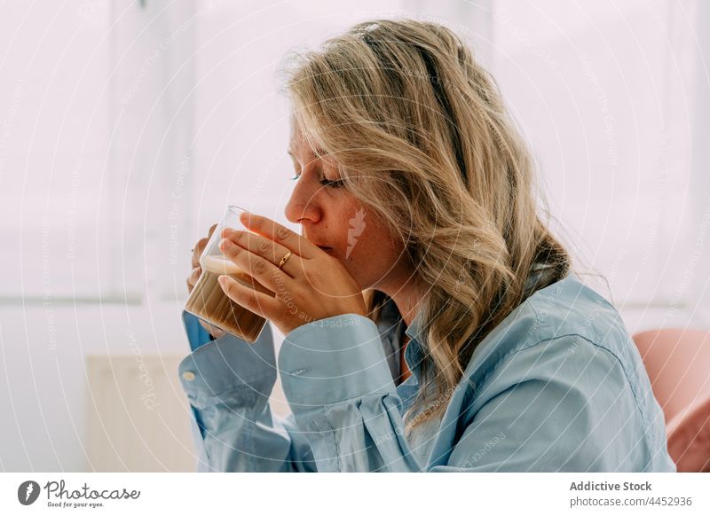 Dreamy woman enjoying delicious latte at home drink coffee hot drink beverage reflective natural aroma foam aromatic cup scent dairy froth milk transparent