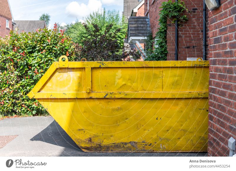 Big Yellow rubbish skip removal trash waste load site hire rent construction industry recycle building bin outdoor home house development street heavy