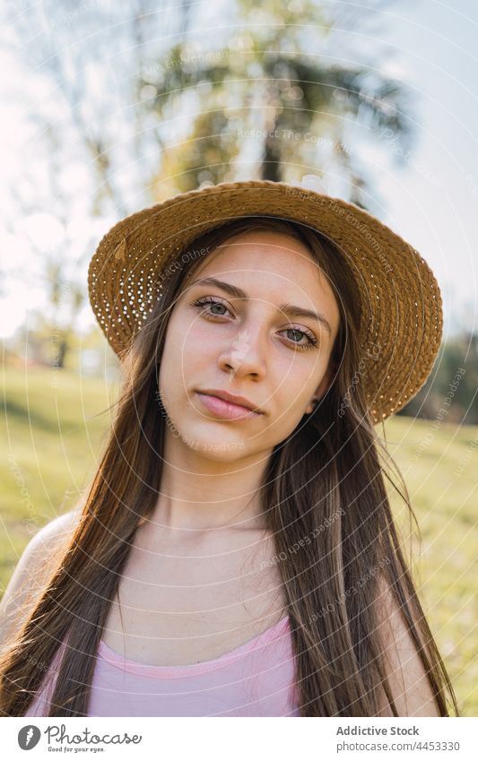 Teenager in straw hat in summer park teenage appearance charming sincere friendly natural portrait tender complexion pleasant feminine material pure wicker
