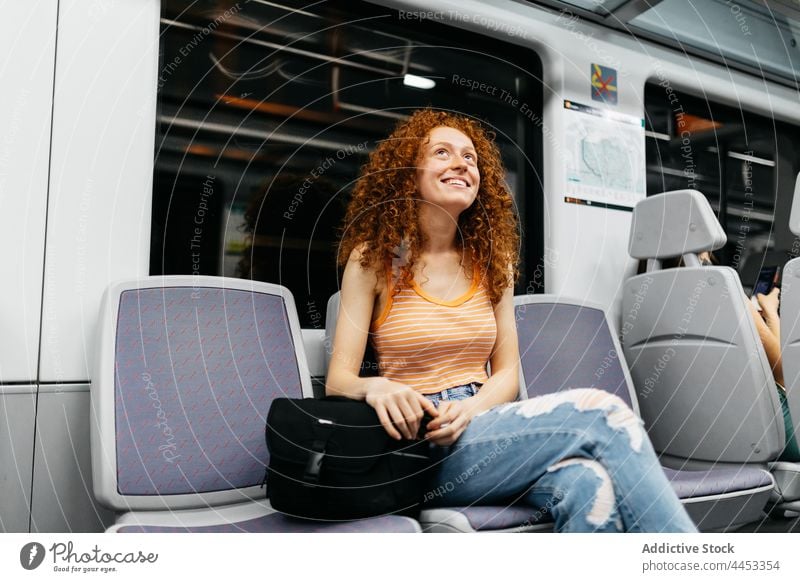 Cheerful passenger with crossed legs on train travel cheerful commute legs crossed candid friendly seat woman charming charismatic ripped jeans crop top smile