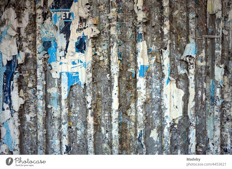 Old grey construction fence made of sectional steel with paper remains of torn off blue posters in the old town of Taksim at the Istiklal Caddesi in Beyoglu in Istanbul at the Bosporus in Turkey