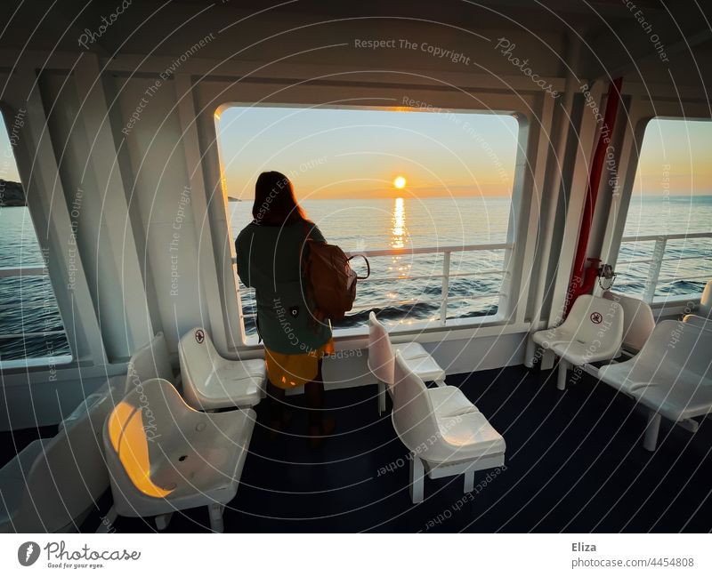 A woman stands at the railing of a ferry and looks across the sea to the sunrise Ferry Railing Ocean Sunrise voyage Wanderlust Vacation & Travel Watercraft