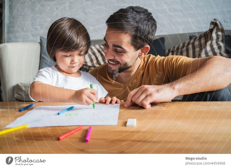 Father and son playing together at home. monoparental drawing father child indoors floor activity lifestyle concept relax love togetherness isolation lockdown
