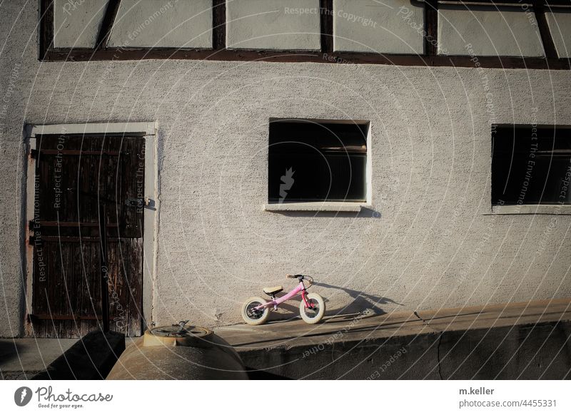 a child's bicycle leaning against a barn Country life Shadow Bicycle Infancy Evening