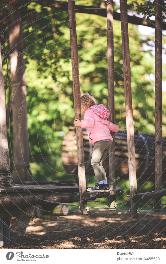 Girl climbing on a playground Playground Climbing balance Balance Concentrate Brave Child Movement Playing Infancy Joy