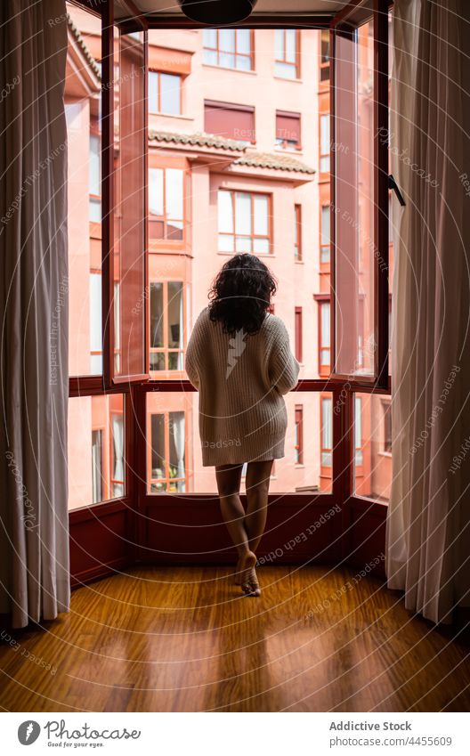 Woman standing near opened window in morning woman apartment harmony gentle peaceful accommodation flat female domestic curtain home barefoot dwell estate
