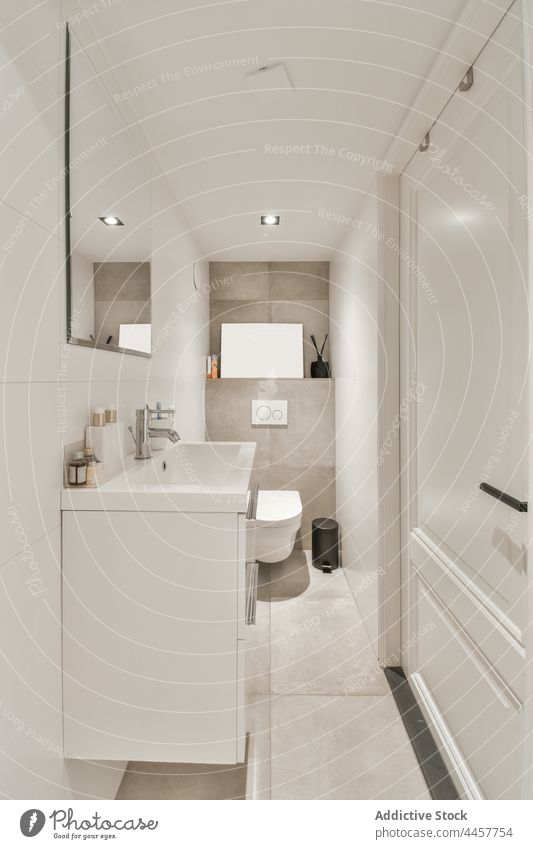 Modern bathroom interior with washbasin against door in house washstand mirror creative design modern style domestic contemporary hygiene toiletry bottle