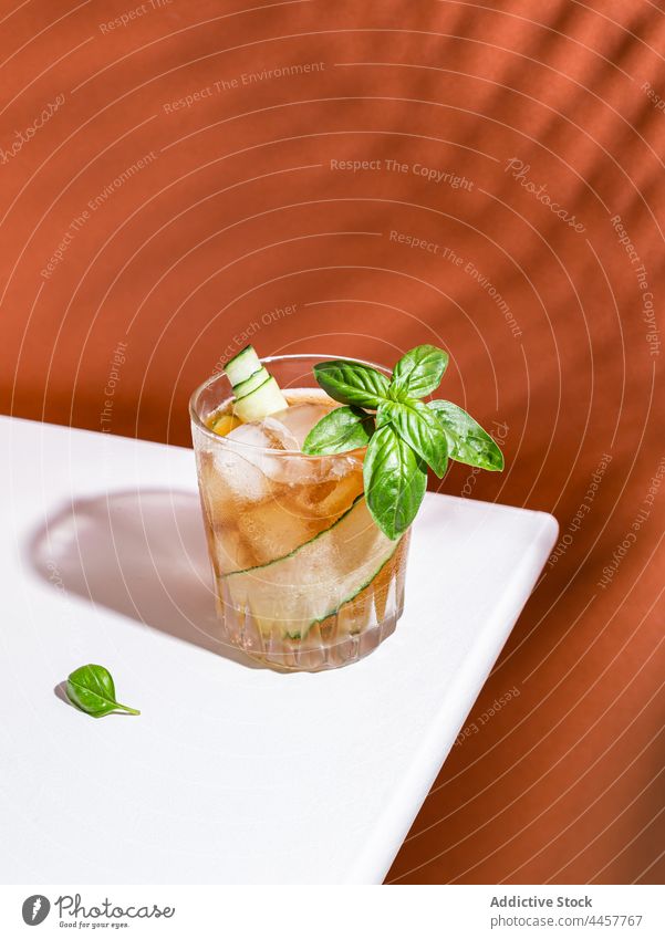 Refreshing cocktail with cucumber and basil rum glass alcohol serve table drink cold refreshment beverage slice delicious portion vegetable ingredient cube
