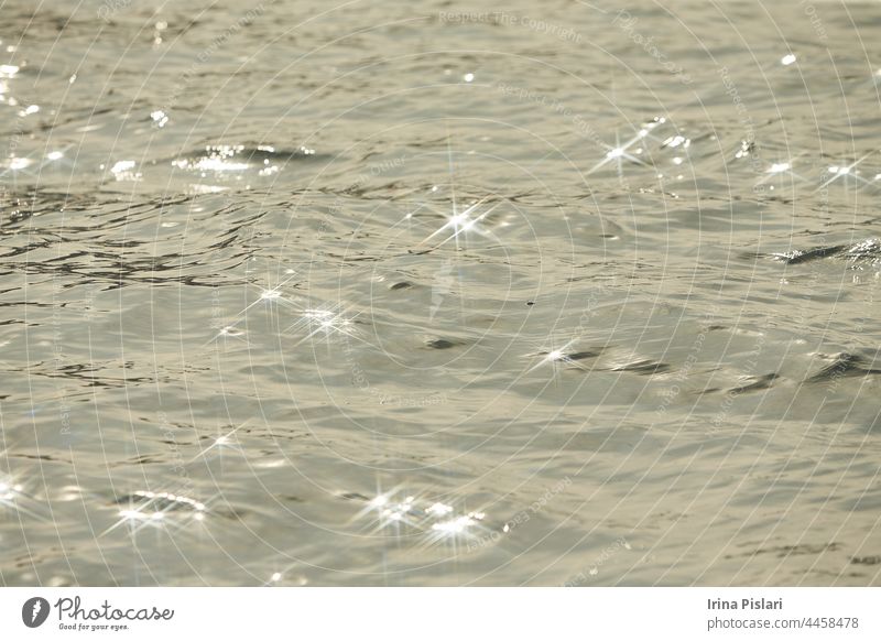 Detail of a sunlight reflecting in glittering sea. sparkler in water - background. sea water with sun glare and ripple. Powerful and peaceful nature concept.