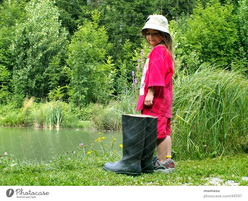 ... Should I or shouldn't I? Child Girl Rubber boots Large Small Habitat Meadow Grass Bushes Water