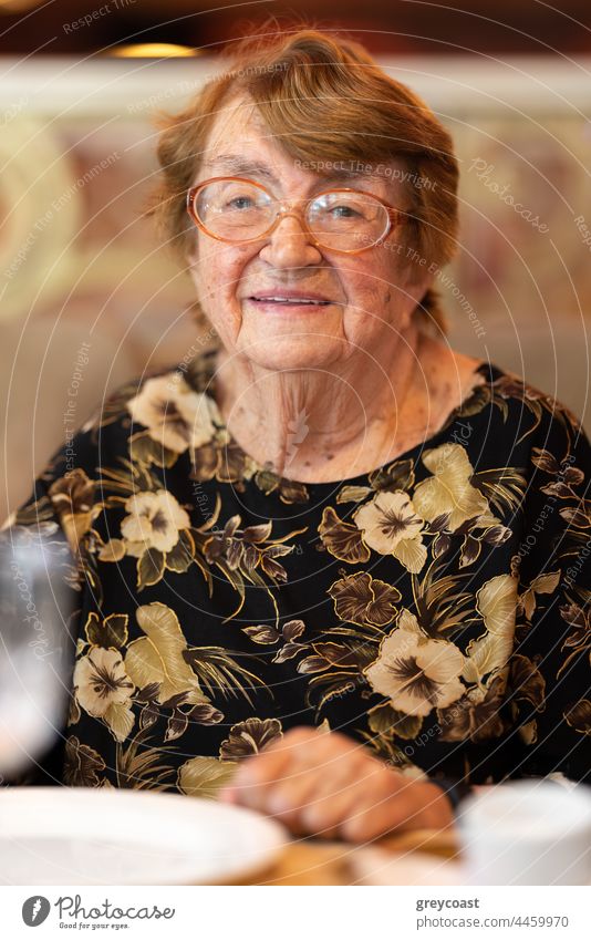 Indoor portrait of a woman in her eighties elderly senior aged retired dinner happy restaurant enjoy 80s cafe lunch glasses joyful lady cheerful grandma granny