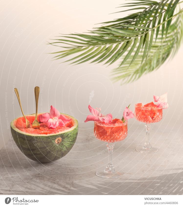 Tasty watermelon cocktails in glasses with half of watermelon decorated with flowers. Summer refreshing drinks tasty summer beverage blended cold food fruits