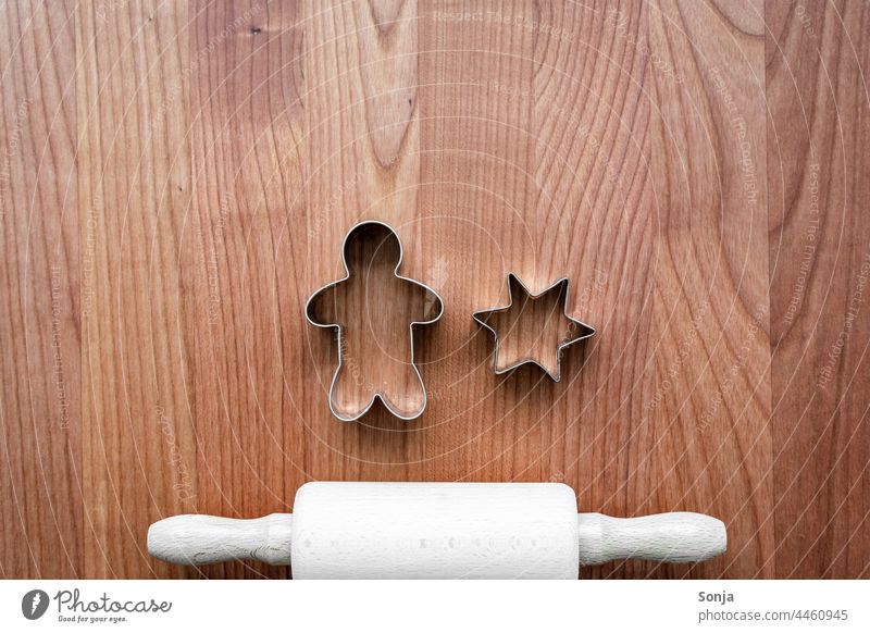 A rolling pin and cookie cutters on a brown wooden table. Top view. Rolling pin Baking Cookie Wooden table Brown plan Christmas & Advent Preparation
