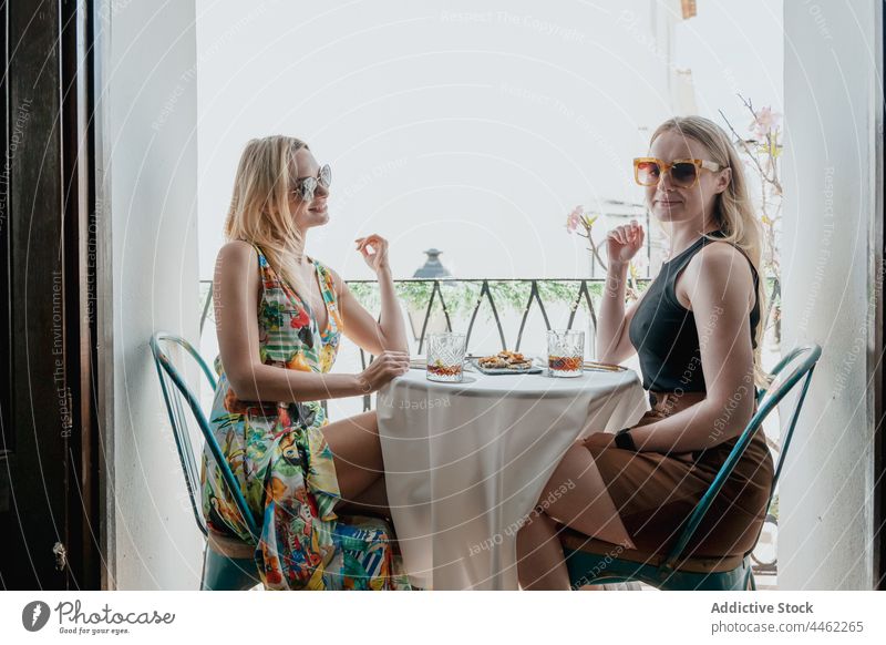 Cheerful women drinking cocktails on balcony friend toast enjoy clink cheers lunch celebrate female together cheerful table best friend glass friendship alcohol
