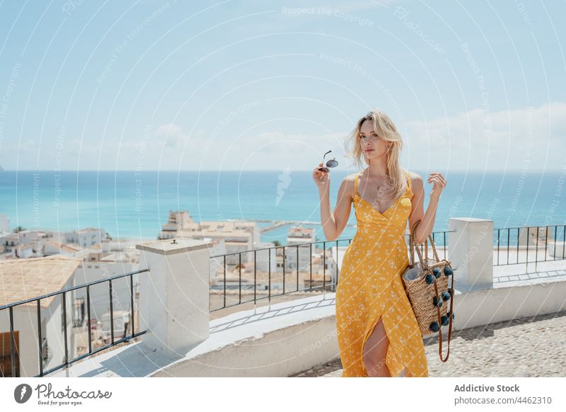 Woman in dress standing on balcony and enjoying seascape woman traveler admire city trip observe coast vacation old female tourism tourist blue sky holiday