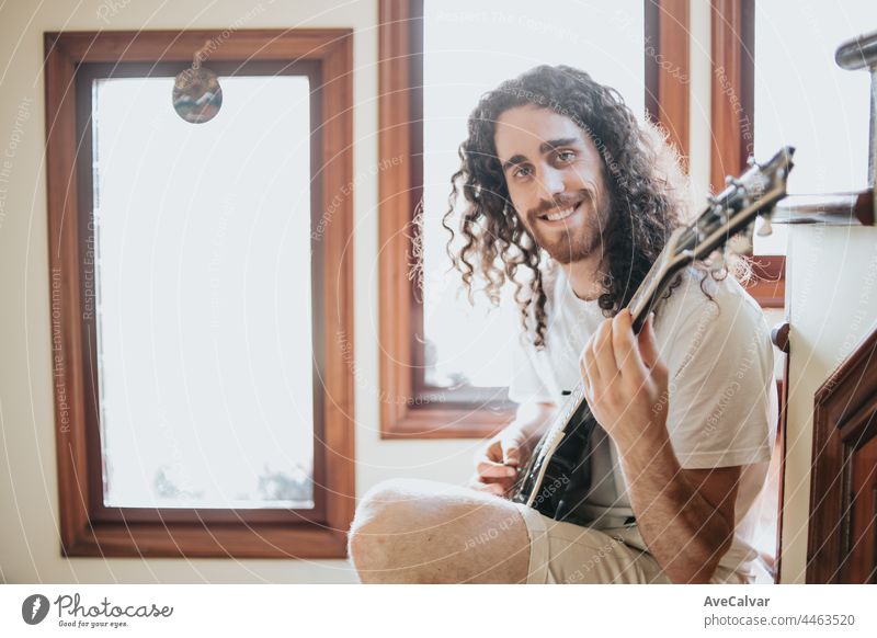 Attractive man with long hair playing acoustic guitar outdoors, hippie, relax, park lifestyle, hobby, copy space music one person guy artist concentration