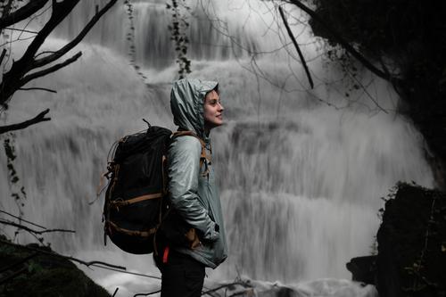 girl in front of a waterfall Waterfall Exterior shot Nature Colour photo River Wet Flow Rock Forest Backpack Natural
