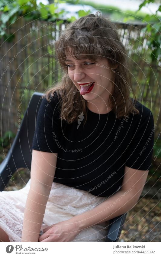 Young woman in the garden sticks out her tongue Woman Grimace Face Mouth Funny portrait Brash Happiness Colour photo Tongue show tongue Facial expression Girl
