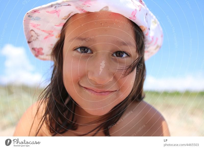 Girl wearing a hat smiling at the camera Cheerful Affection activities family outdoors focus Invite Open aid start Beginning New Acceptance Friendliness Infancy