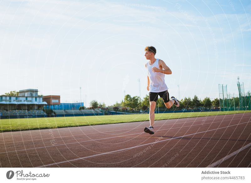 Runner jogging during workout on track in stadium runner sport training activity cardio motion track and field man athlete warm up practice fast town sportsman