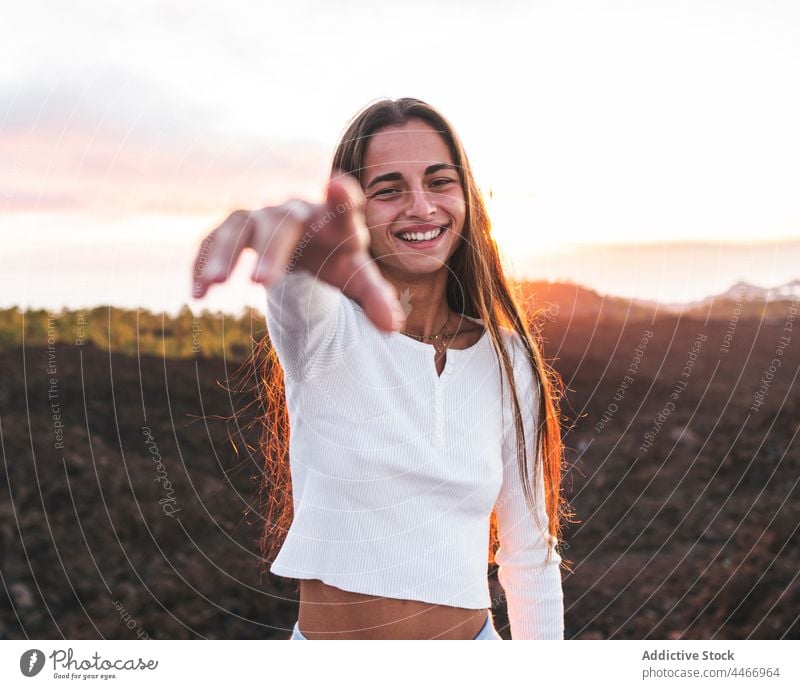 Smiling teenager with long hair against sea in mountains smile outstretch friendly sincere charming sunset sky portrait ocean highland sundown evening cheerful