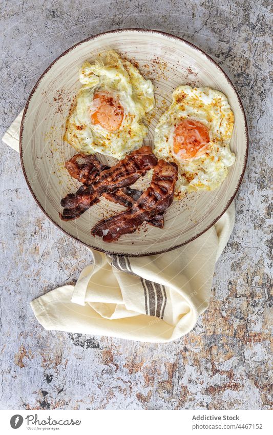 Delicious breakfast of fried eggs and bacon slices food meal nutrient tasty plate towel ornament stripe wheat baked piece spice nutrition delicious