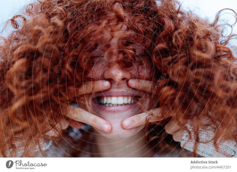 Cheerful ginger woman showing victory gesture laugh two fingers fun human face joy happy redhead female optimist v sign curly hair eyes closed portrait
