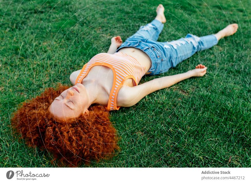 Relaxed woman lying on grassy lawn sleep nap relax peaceful quiet rest harmony female eyes closed serene environment calm tranquil carefree nature idyllic
