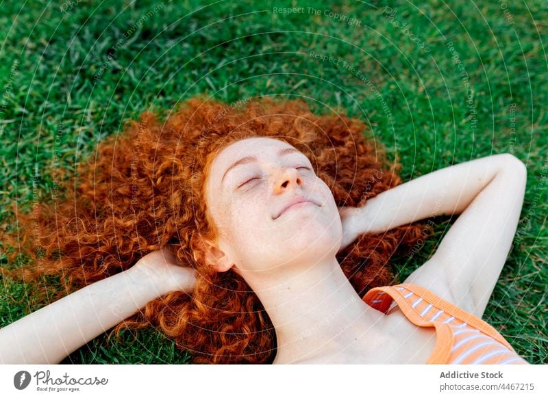 Cheerful woman with hands behind head lying on grass happy relax individuality lawn chill enjoy delight pleasure female cheerful appearance glad optimist