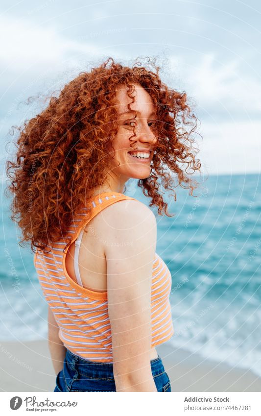 Cheerful woman looking at camera on seashore happy relax pleasure expressive freedom personality individuality enjoy female cheerful portrait carefree pleasant