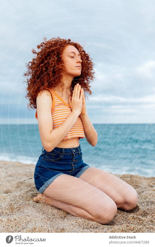 Woman with hands on chest meditating on sandy beach woman sea yoga meditate gesture spirit namaste mental stress relief female harmony mindfulness peaceful