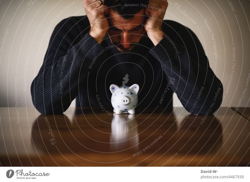 Piggy bank and finances - insecurity and headache of a man Fear of the future headaches savings Man Money box Debts Fears piggy bank Crisis depleted concept