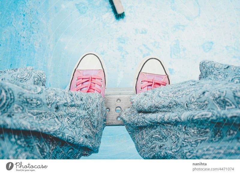 High angle view of a young woman legs in an empty pool feet blue pink background abstract high perspective sneakers opposites cool cold tones trendy texture