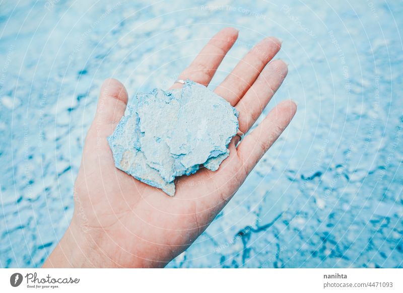 Hand holding a blue pice of a broken wall hand piece cracked floor pool fragile fragility delicate rest maintenance background wallpaper surface grunge