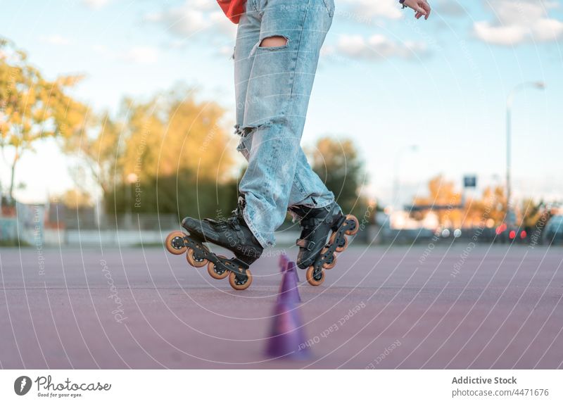Roller skater practicing trick on skate park person activity roller roller blades cone practice training sport leg jeans active lifestyle urban sporty challenge