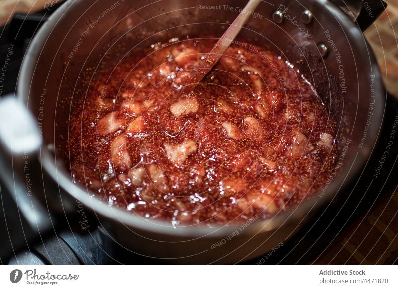 Crop person preparing fig jam in pressure cooker in kitchen prepare stir natural sweet culinary recipe organic delicious homemade fruit tasty house marmalade