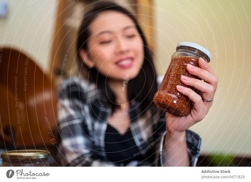 Asian woman with jar of fig jam at home sweet treat natural organic delicious homemade fruit tasty house marmalade yummy transparent lid glass asian ethnic