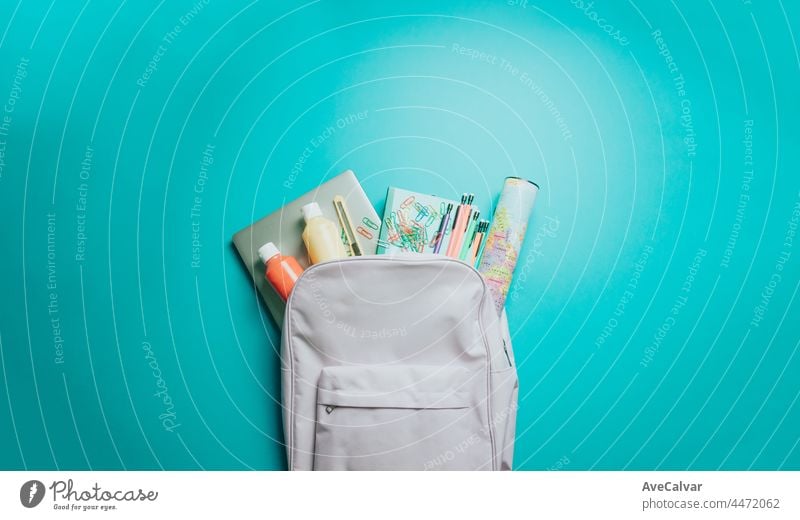 Backpack with colorful school supplies on purple background. Back to school. Flat lay, top view, copy space, Minimal design blackboard college education