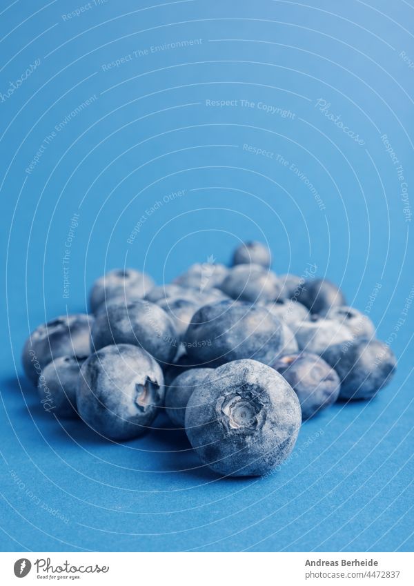 A heap of blueberries on a blue background super food organic bunch bio freshness produce agriculture summer diet harvest many healthy blueberry on blue sweet