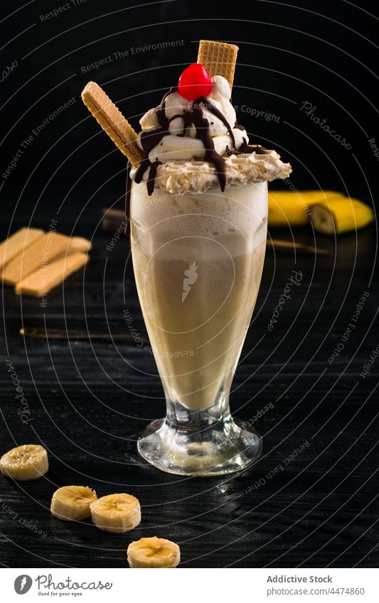 Yummy milkshake topped with cream and waffles banana whipped dessert sweet chocolate drink food glass tasty treat yummy fruit delicious cherry portion mix