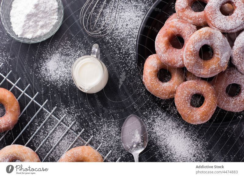 Delicious doughnuts with powdered sugar fried dessert sweet pastry calorie confectionery milk plate rack messy food treat table serve tasty delicious yummy