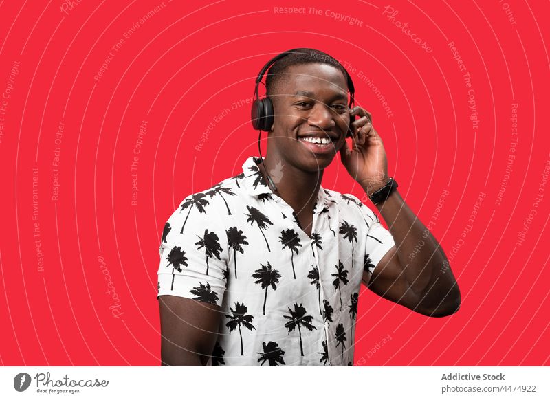 Black man enjoying music in modern headphones listen hobby wireless entertain glad pleasure male happy delight gadget sound song playlist carefree