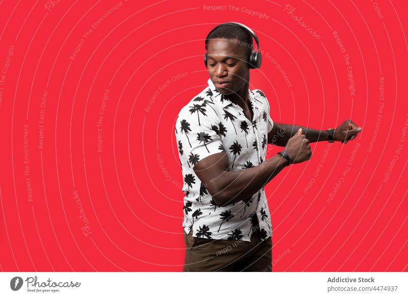 Black man enjoying music in modern headphones listen hobby dance wireless entertain glad pleasure male happy delight gadget sound song playlist carefree