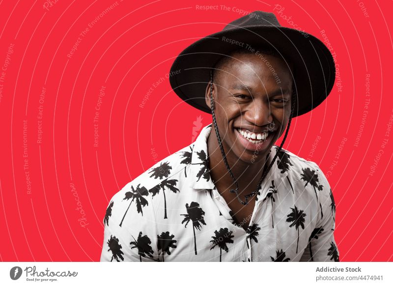 Happy black man in trendy outfit in studio confident personality style masculine portrait gaze self esteem cool appearance male model individuality self assured
