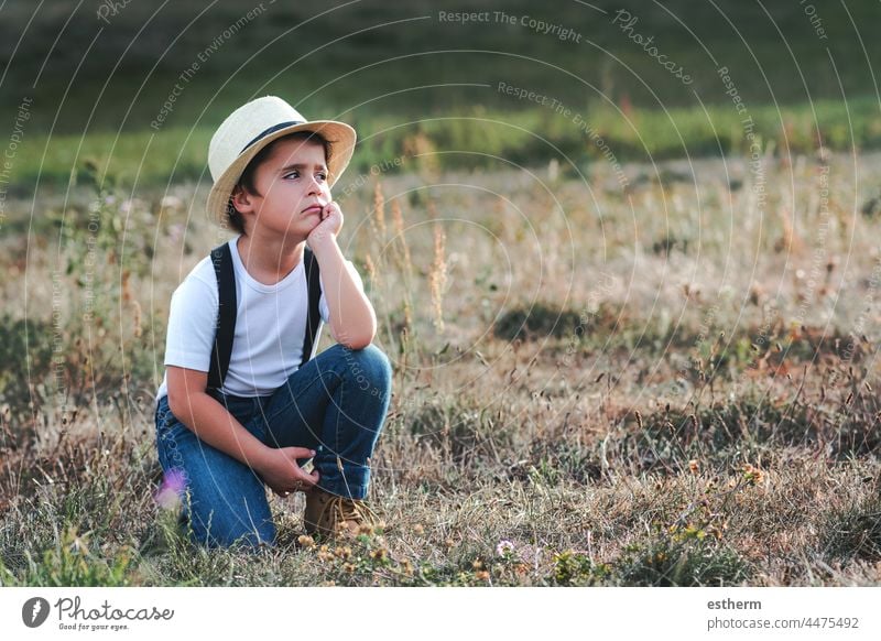 Thoughtful child with white t-shirt and hat childhood nostalgic thoughtful kid loneliness lonely future expression freedom innocence unhappy portrait serious