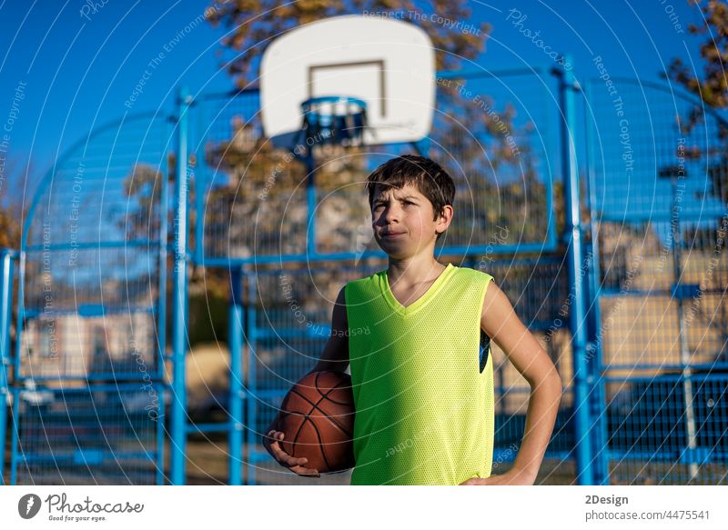 Teenage boy holding a basketball on a court Activity Caucasian City Street Court Lifestyle Male Mid Adult Modern Outdoors Portrait Sport Young active america