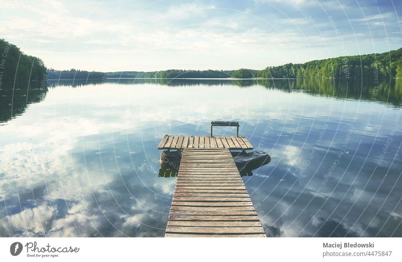 Wooden pier at calm Lipie Lake, color toned picture, Poland. nature water lake sky horizon reflection scenic peaceful effect beautiful landscape day still relax