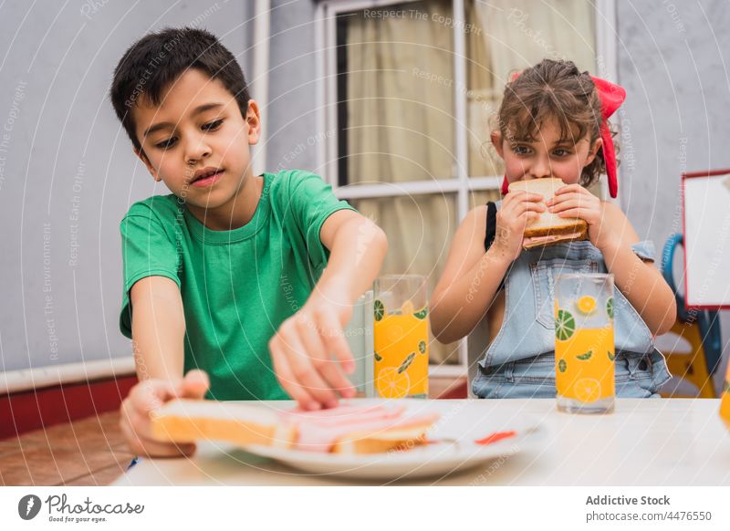 Cheerful kids with tasty sandwiches children food childhood snack appetite taste bread eat hungry light room adorable cute girl sibling yummy delicious positive