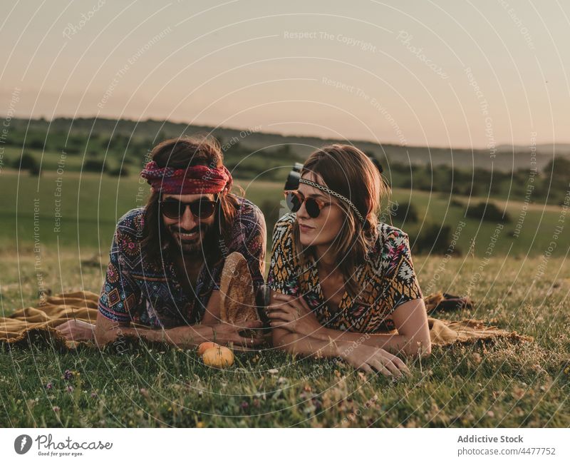 Couple looking away while lying down in a meadow woman nature content positive peaceful serene field countryside grass lifestyle carefree romantic flower summer